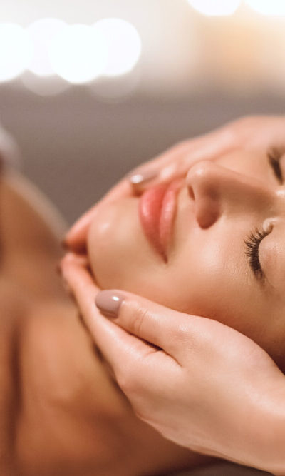 Facial Beauty Treatment. Woman Getting Face Massage At Spa Salon, Closeup